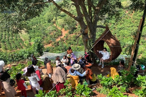 Du khách đứng xếp hàng chờ chụp hình check-in tại một khu du lịch